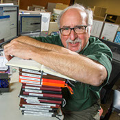 Eric Jay Toll, journalist, writer, author Photo of Eric Jay Toll standing in fronr of a blooming desert plant in Scottsdale, Arizona.